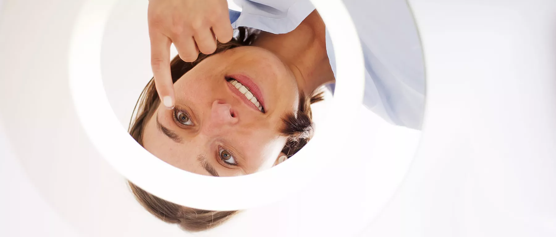 Frau setzt sich vor einem Spiegel Kontaktlinsen ein